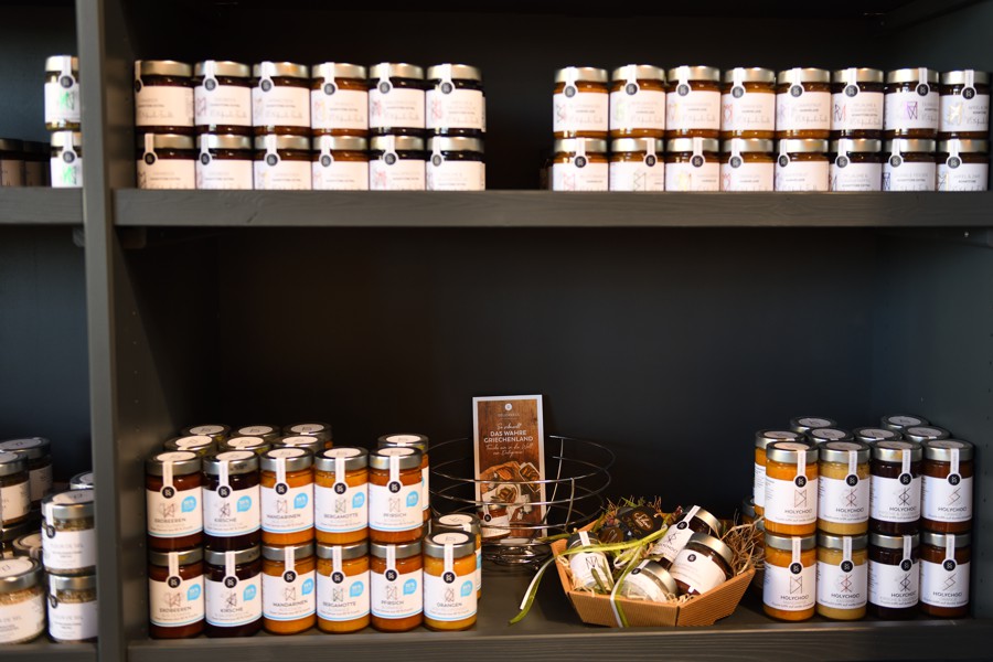 Regal mit vielen Gläsern von Feinkostprodukten, darunter Aufstriche und Chutneys in einheitlicher Verpackung.